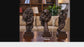 Three bronze sculptures on a marble coffee table in a living room setting.

